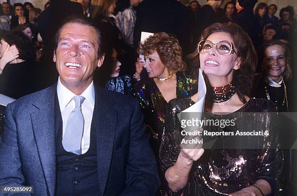 British actor Roger Moore and Italian actress Sophia Loren smiling at Italian fashion designer Valentino's fashion show at the Excelsior Hotel in...
