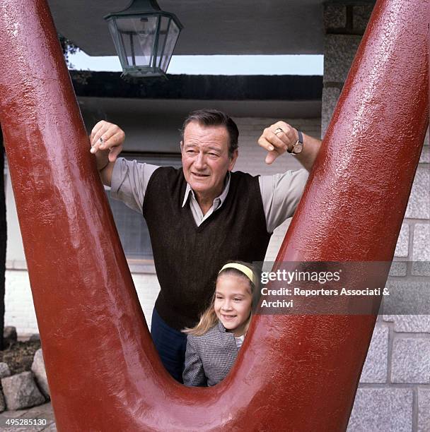 American actor John Wayne and his daughter Aissa posing in the villa where he lives while shooting the film In Harm's Way. 1965