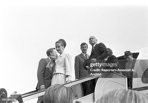 Russian-born American actor Yul Brinner walking down the aircraft ladder at the airport with his wife Doris Kleiner for a film festival. Vienna 1968