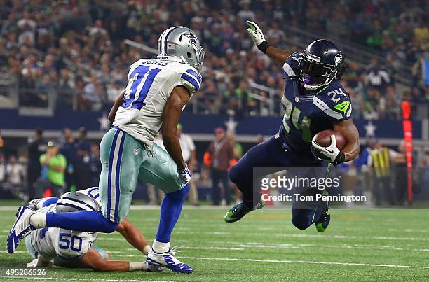 Marshawn Lynch of the Seattle Seahawks carries the ball against Sean Lee of the Dallas Cowboys and Byron Jones of the Dallas Cowboys in the second...