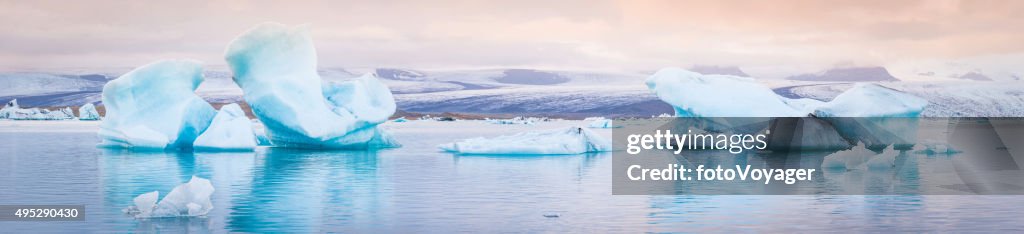 Pale blue icebergs floating in tranquil Arctic ocean lagoon Iceland