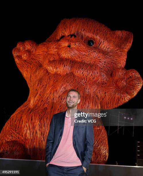 Dutch artist Florentijn Hofman poses with his latest artwork the 'Pink Kitten', which is made of strips of bamboo, during the Shanghai Design Week at...