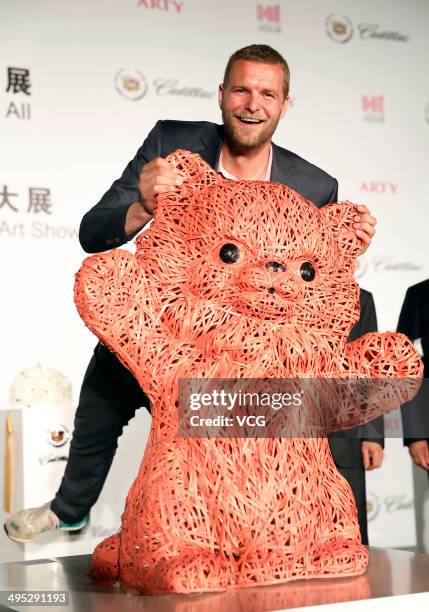 Dutch artist Florentijn Hofman poses with his latest artwork the 'Pink Kitten', which is made of strips of bamboo, during the Shanghai Design Week at...