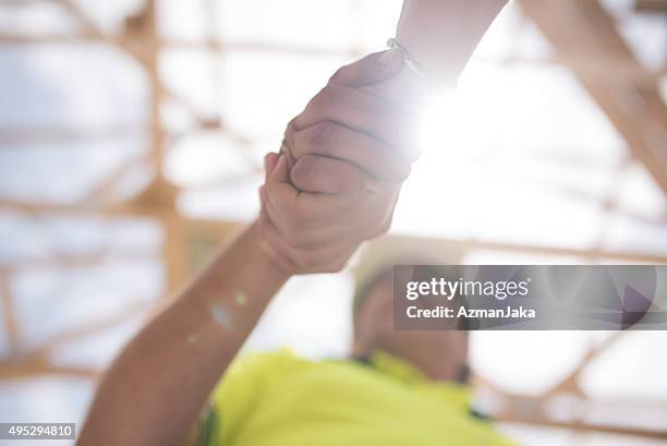 construction worker shaking hands with manager - beëindigen stockfoto's en -beelden