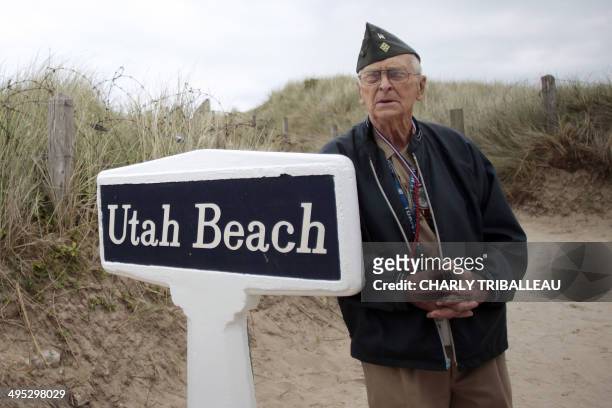 Veteran Charles Wilson from Kentucky, poses for a photograph next to a sign at Utah beach, in Sainte-Marie-du-Mont, northwestern France, on June 2,...
