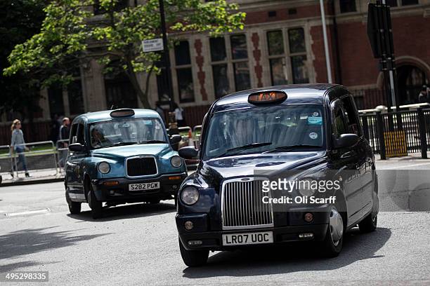 Taxis drive on the streets of Westminster on June 2, 2014 in London, England. The controversial mobile application 'Uber', which allows users to hail...