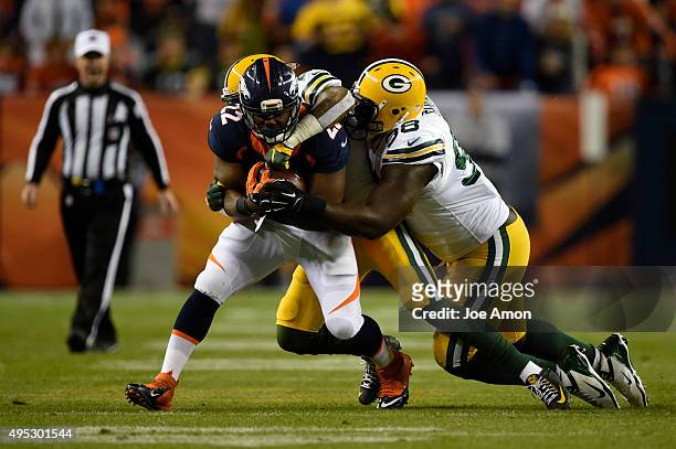 Anderson of the Denver Broncos is brought down by Ha Ha Clinton-Dix of the Green Bay Packers and Letroy Guion of the Green Bay Packers. The Denver...