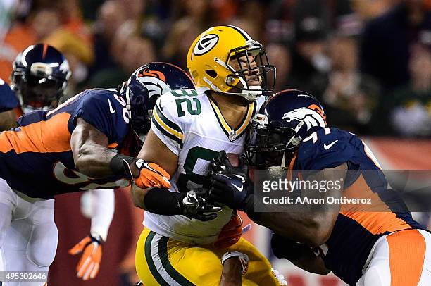 David Bruton , Chris Harris and Malik Jackson of the Denver Broncos make a tackle on Richard Rodgers of the Green Bay Packers on a short pass...