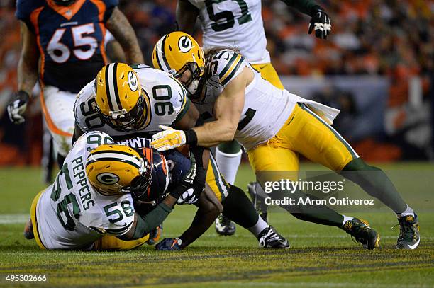 Chris Harris of the Denver Broncos is tackled by Sam Barrington , B.J. Raji and Clay Matthews of the Green Bay Packers in the second quarter. The...