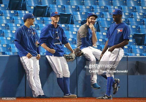 Roberto Osuna of the Toronto Blue Jays shares a laugh with Mark Lowe and Drew Hutchison and LaTroy Hawkins during batting practice before MLB game...