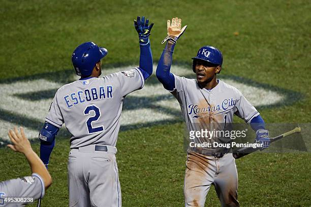 Jarrod Dyson of the Kansas City Royals celebrates with Alcides Escobar after scoring the go ahead run hit by Christian Colon in the twelfth inning...
