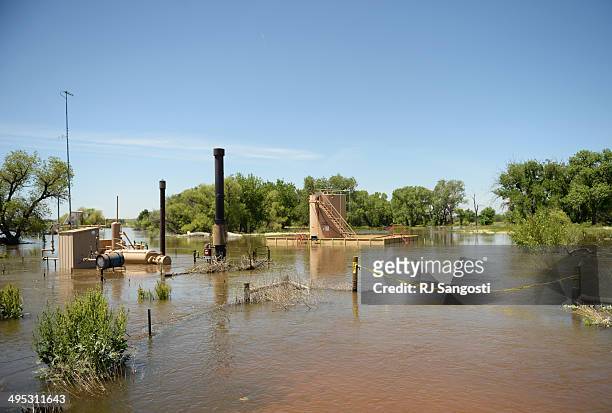 Oil and gas equipment is surrounded in flood water near the Poudre River in northwest Greeley, June 2, 2014. A flood warning for the Poudre River...