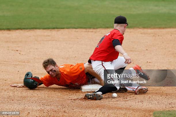 Bryant Burleson of the Texas Tech Red Raiders can not control the ball as Tyler Palmer of the Miami Hurricanes steals second base in the tenth inning...