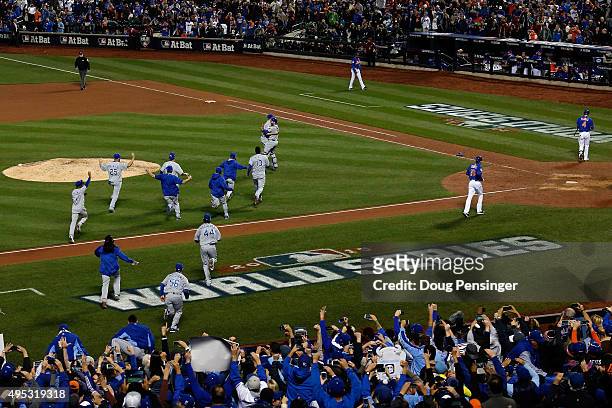 The Kansas City Royals dugout runs onto the field to celebrate with Wade Davis after defeating the New York Mets in Game Five of the 2015 World...