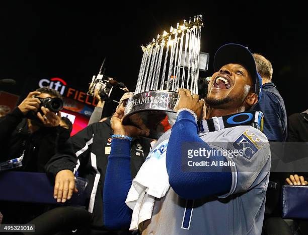 Jarrod Dyson of the Kansas City Royals celebrates with the Commissioner's Trophy after defeating the New York Mets to win Game Five of the 2015 World...