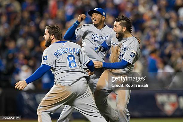 Mike Moustakas, Eric Hosmer and Alcides Escobar of the Kansas City Royals celebrate on the field after defeating the New York Mets in Game 5 of the...