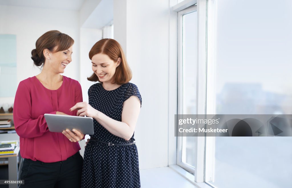 Smiling business women with digital tablet