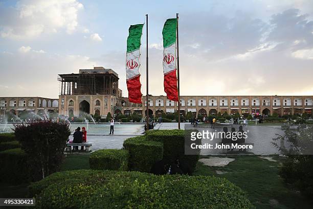 People spend sunset together in the Unesco-listed Naqsh-eJanan Square as Iranian flag banners flap in the wind on June 2, 2014 in Isfahan, Iran....