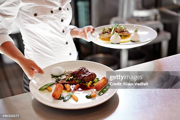 waiter picking up dishes in kitchen at restaurant - servire alimenti e bevande foto e immagini stock