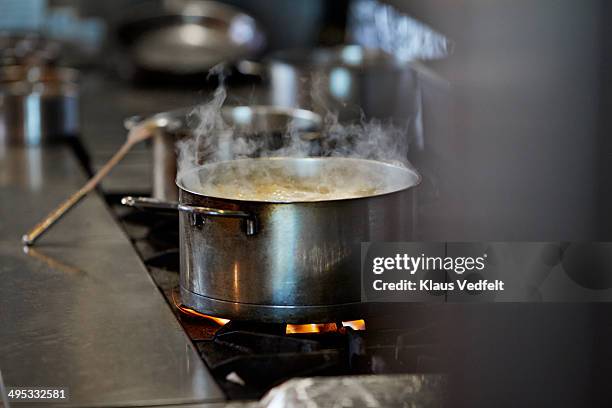 font cooking on stow in kitchen at restaurant - pan keukengereedschap stockfoto's en -beelden