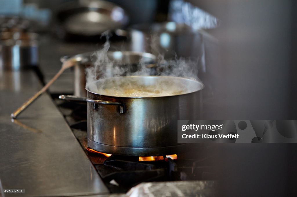 Font cooking on stow in kitchen at restaurant