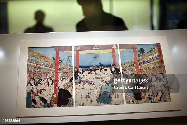 Visitor views exhibits behind an 1852 woodblock print by Utagawa Kunisada II entitled Great Sumo Tournament Fundraiser during a press preview for the...