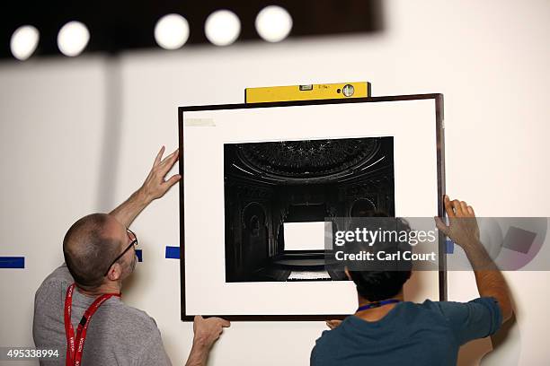 Staff members hang a 1992 photograph by Hiroshi Sugimoto titled 'Alhambra, San Francisco' during a press preview for the Victoria and Albert Museum's...