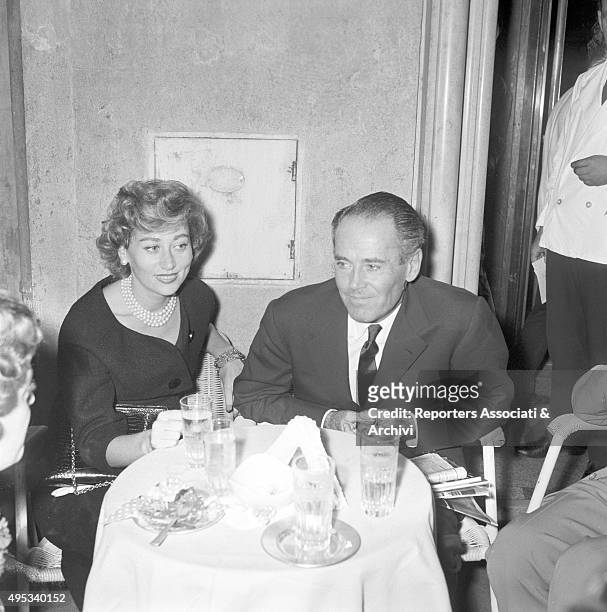 American actor Henry Fonda sitting at a table at Casina delle Rose of Via Veneto beside his wife Afdera Franchetti. Rome, 18th September 1958
