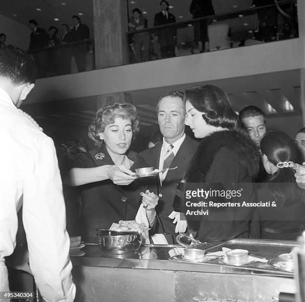 American actor Henry Fonda and his wife and Italian baroness Afdera Franchetti standing at the bar in the hall of Eliseo theatre in Rome with...