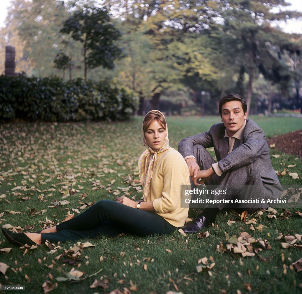 Alain Delon and his wife Nathalie sitting on the grass