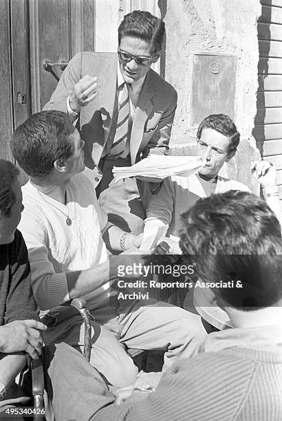 Italian director Pier Paolo Pasolini talking to Italian actor Franco Citti during a break on the set of the film Accattone. Around them, some...