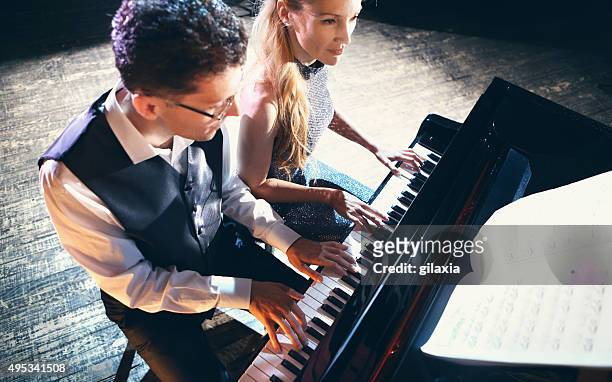 two people playing piano. - duet stock pictures, royalty-free photos & images