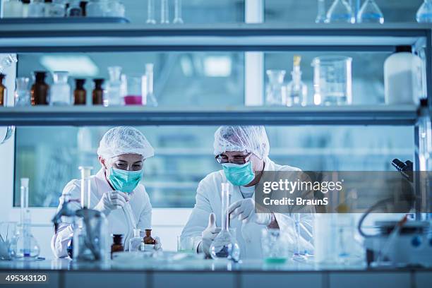 scientists analyzing chemical substances for a new research. - microbiologie stockfoto's en -beelden