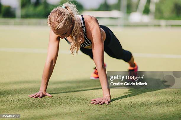 woman doing pushup. - flexiones fotografías e imágenes de stock