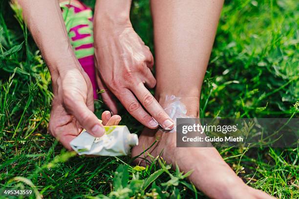 woman treating her foot ankle. - verstauchung stock-fotos und bilder