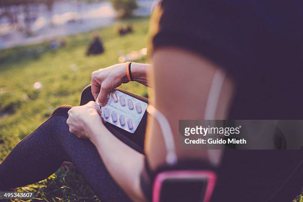 woman taking a pill after workout. - exercise pill stockfoto's en -beelden