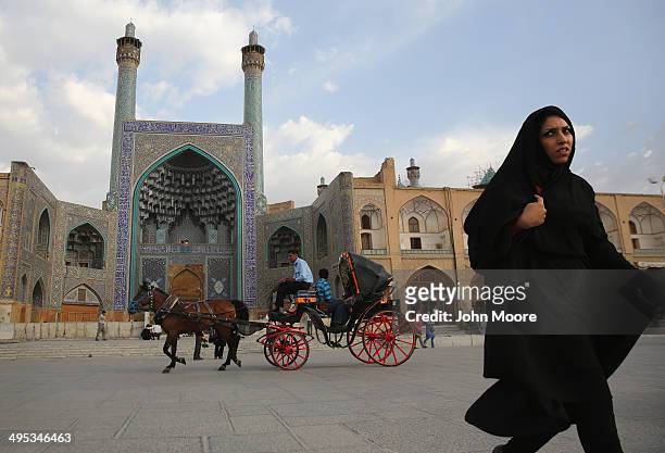 People ride a horse and carriage in Isfahan's Unesco-listed central square on June 2, 2014 in Isfahan, Iran. Isfahan, with its immense mosques,...