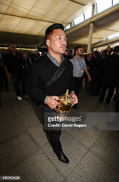 Keven Mealamu, of Rugby World Cup winners, the New Zealand All Blacks, carries the Webb Ellis Cup as the team arrive at Heathrow Airport at the start...