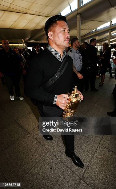 Keven Mealamu, of Rugby World Cup winners, the New Zealand All Blacks, carries the Webb Ellis Cup as the team arrive at Heathrow Airport at the start...