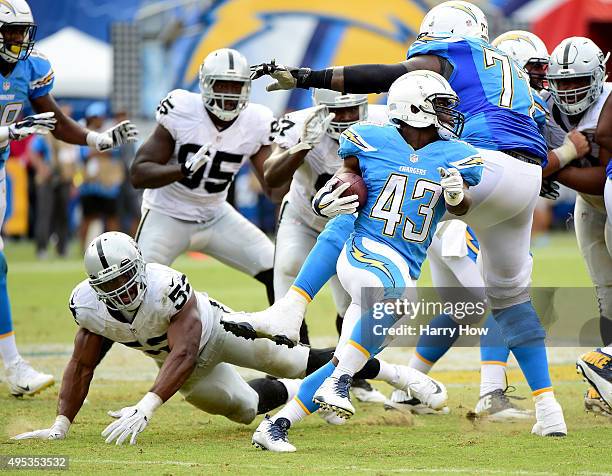 Branden Oliver of the San Diego Chargers eludes the tackle of Malcolm Smith of the Oakland Raiders at Qualcomm Stadium on October 25, 2015 in San...