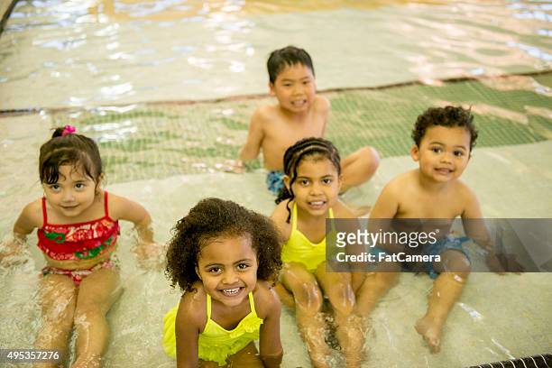 little kids playing in the pool - kids swimwear stock pictures, royalty-free photos & images
