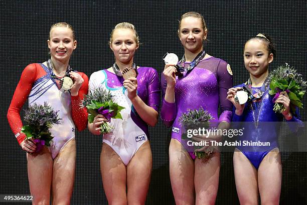 Gold medalists Madison Kocian of the United States, Daria Spiridonova of Russia, Viktoriia Komova of Russia and Fan Yilin of China pose on the podium...