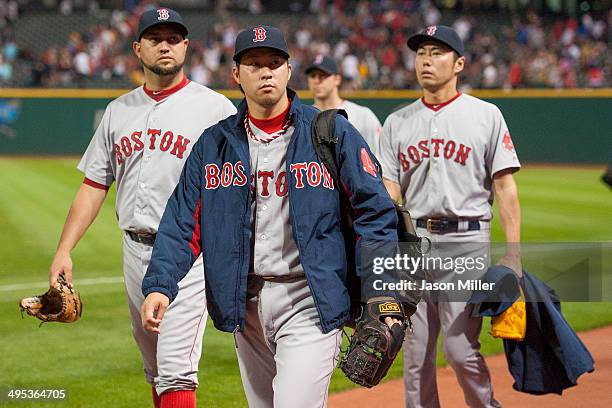 Relief pitchers Edward Mujica, Junichi Tazawa and Koji Uehara of the Boston Red Sox walk in from the right field bullpen after the Cleveland Indians...