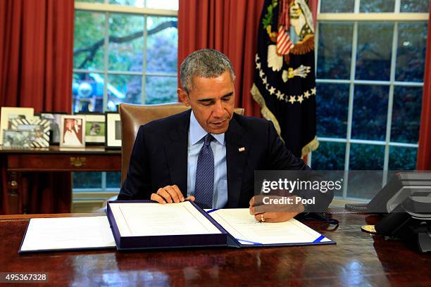 President Barack Obama signs the bipartisan budget bill 2015 into law in the Oval Office of the White House November 2, 2015 in Washington, DC. Obama...