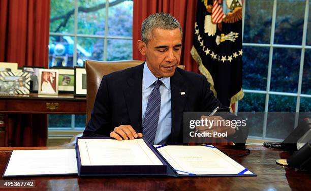 President Barack Obama signs the bipartisan budget bill 2015 into law in the Oval Office of the White House November 2, 2015 in Washington, DC. Obama...