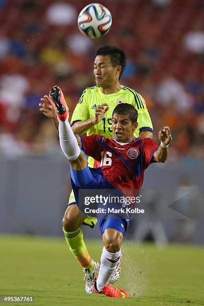 Christian Gambo of Costa Rica clears the ball under pressure from Yasuyuki Konno of Japan during the International Friendly Match between Japan and...