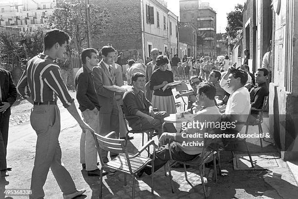 Italian director Pier Paolo Pasolini holding the script surrounded by the extras and the actors, among which Italian actor Franco Citti, during a...