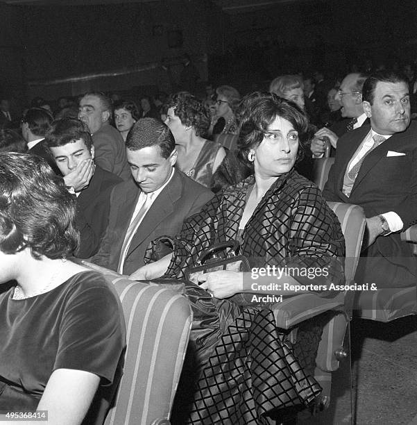 Italian actress Anna Magnani attending a film première with her son Luca and a friend. Rome, 1959