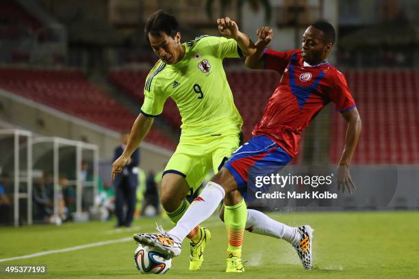 Shinji Okazaki of Japan is tackled by Junior Diaz of Costa Rica during the International Friendly Match between Japan and Costa Rica at Raymond James...