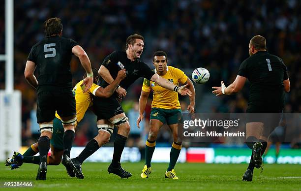 Richie McCaw of New Zealand offloads to Joe Moody of New Zealand during the 2015 Rugby World Cup Final match between New Zealand and Australia at...